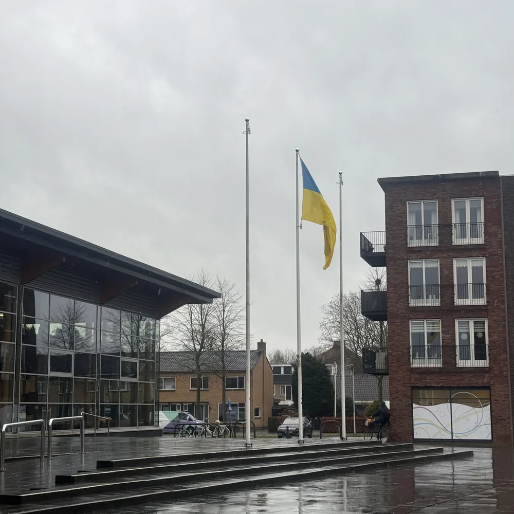 Oekraïense vlag tussen gebouwen op een regenachtig plein