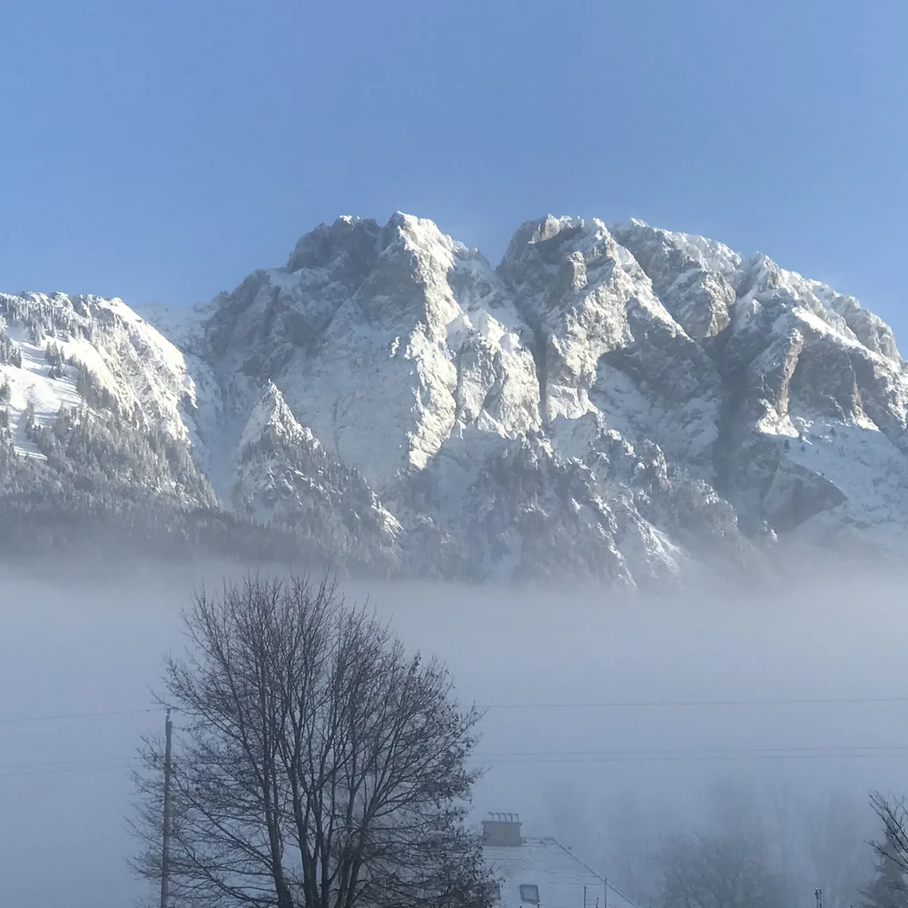 Besneeuwde Reißkofel boven laaghangende bewolking
